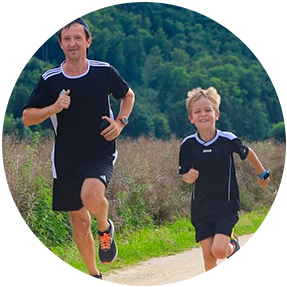 Vater und Sohn joggen gemeinsam im Freien, das Kind trägt eine Xplora Smartwatch für Kinder zur sicheren GPS-Standortverfolgung beim Sport.